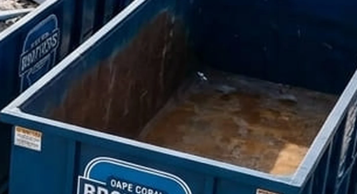 A clean, correctly-labeled 40 yard Cape Coral Brothers Dumpster Rental roll-off container staged at the company yard
